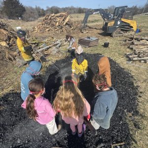 Flame cap kiln demo at Allen Farm with preschool cooperative At Home in the Woods in 2025. Photo by Talia Weingarten.